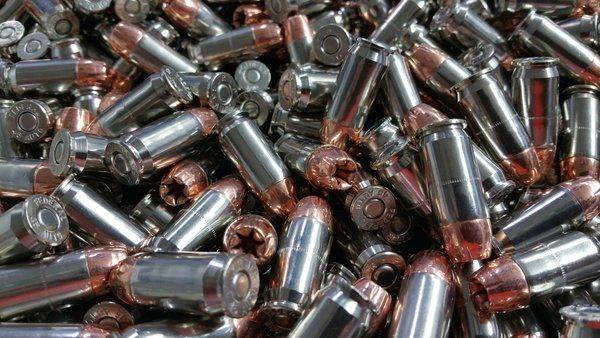 Loose 45 acp (automatic colt pistol) ammo in a pile with shiny clean shells.