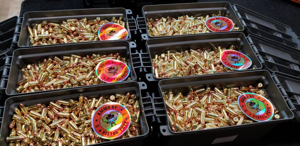 Ammo cans with lids open showing shiny brass ammunition with stickers in each one that say Ammo by Pistol Pete